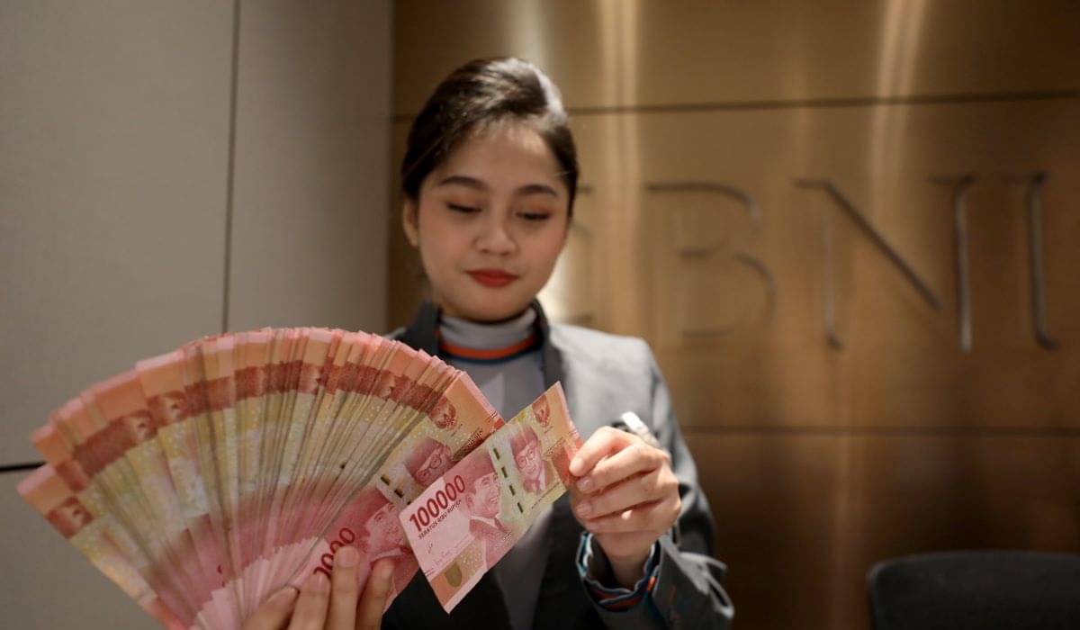 Petugas menunjukkan mata uang rupiah di salah satu kantor cabang PT Bank Negara Indonesia (BNI) Tbk. di Jakarta, Jumat (23/2/2024). 