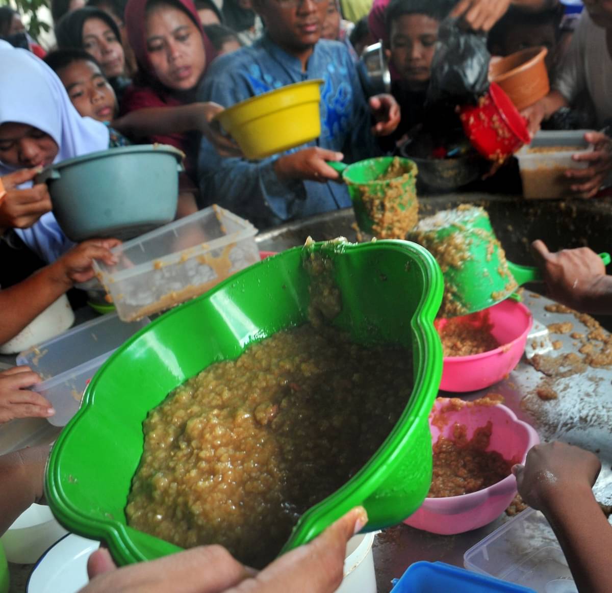 Ilustrasi: Warga menyerbu petugas yang membagikan bubur Asyura di kawasan 12 Ulu Palembang, Sumatera Selatan, Selasa (11/10/2016)