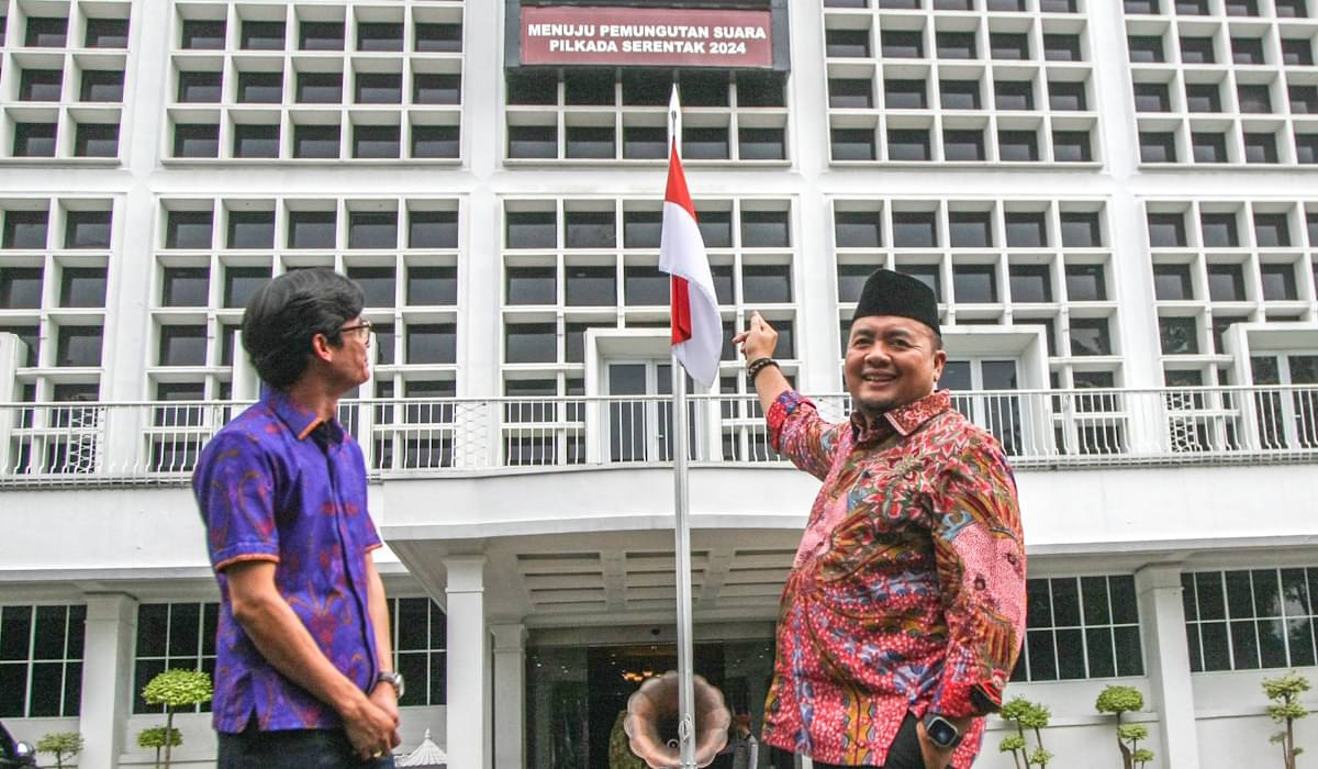 Plt KPU Mochamad Afifuddin (kanan) berbincang dengan Anggota KPU August Mellaz dengan latar belakang count down menuju Pilkada 2024