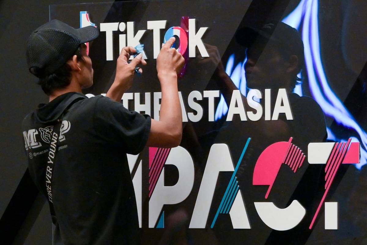 Seorang pekerja menyelesaikan pembuatan logo TikTok.
