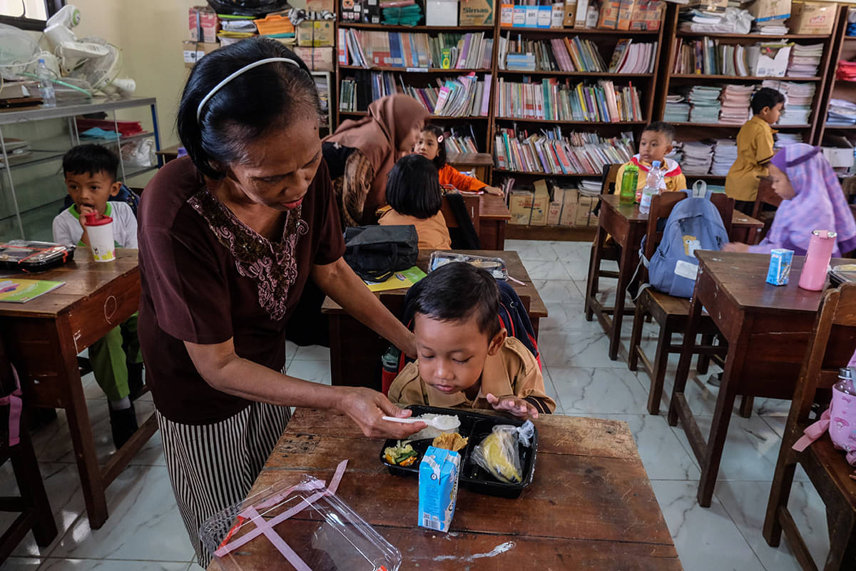  Wali murid dan guru membantu menyuapi makanan saat simulasi program makan bergizi gratis di SD Negeri Tugu, Solo, Jateng, Jumat (26/7)
