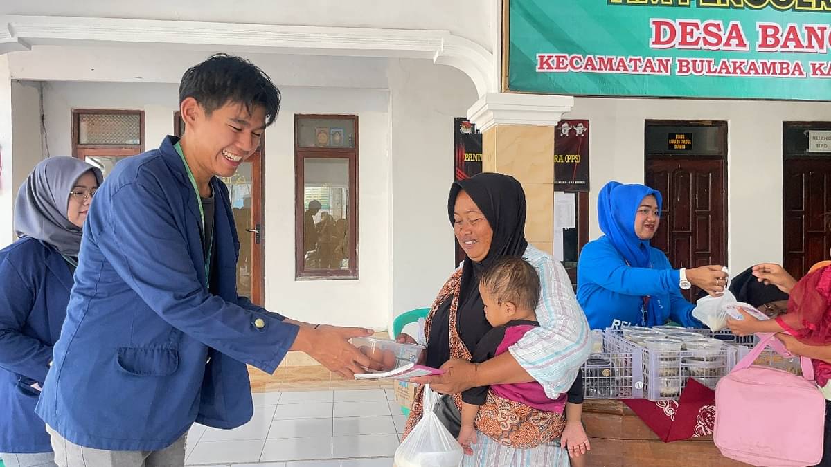 Mahasiswa KKN-T IPB University Christo Glory, memberikan abon telor kepada seorang ibu