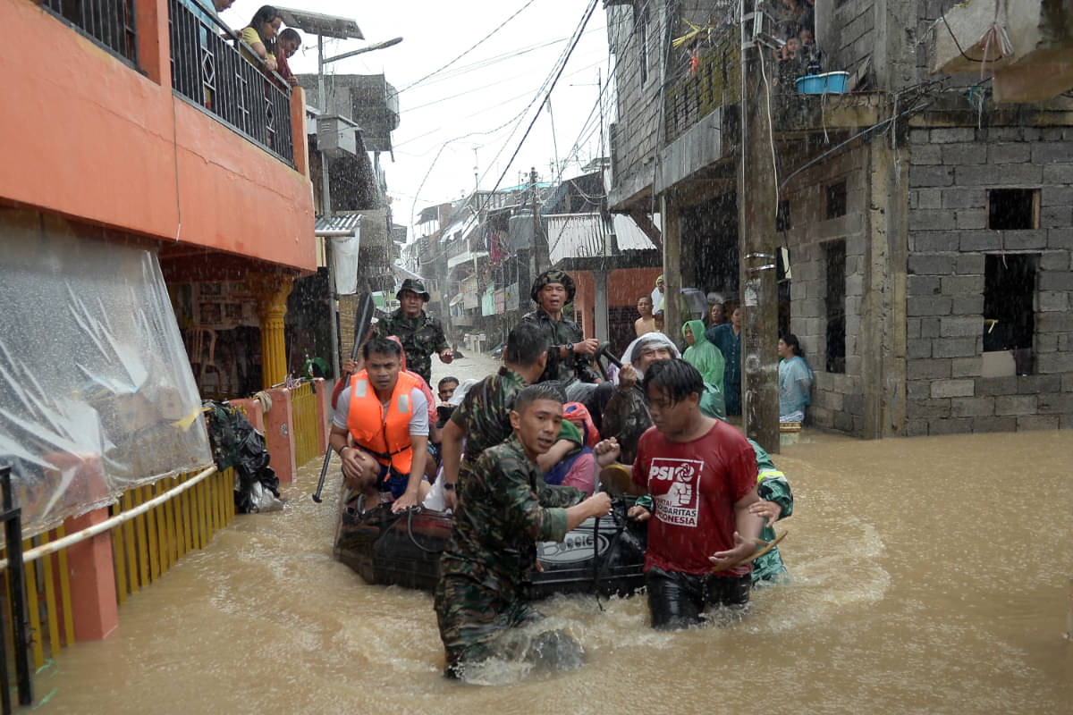 Anggota TNI mengevakuasi sejumlah warga dari rumahnya yang terendam banjir di Manado, Sulawesi Utara