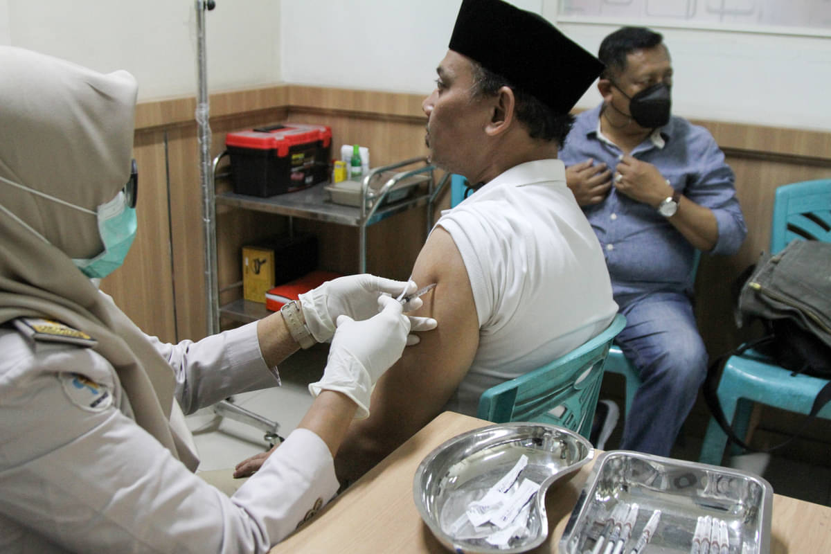 Petugas kesehatan menyuntikkan vaksin meningitis kepada calon jamaah umrah di Sidoarjo, Jawa Timur. 