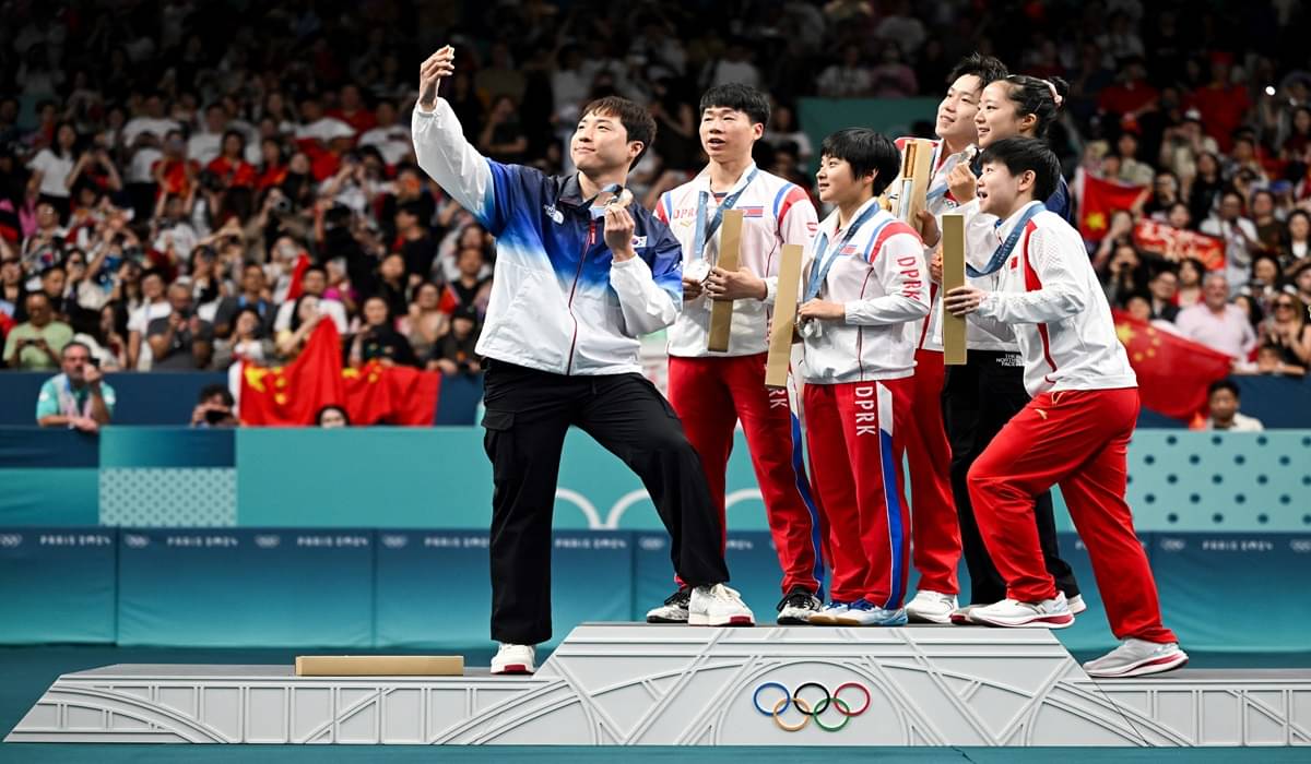 Aksi swafoto atlet tenis meja asal Korea Selatan bersama atlet Korea Utara dan Tiongkok di podium juara Olimpiade Paris 2024.